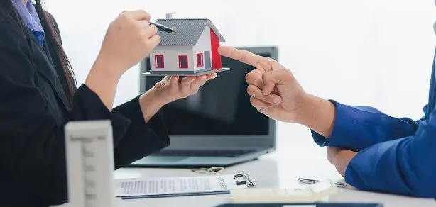 住宅模型を使って顧客と打ち合わせをしている場面